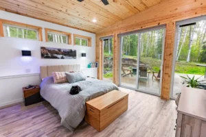 This bedroom opens up to a sprawling deck with a spacious yard in behind