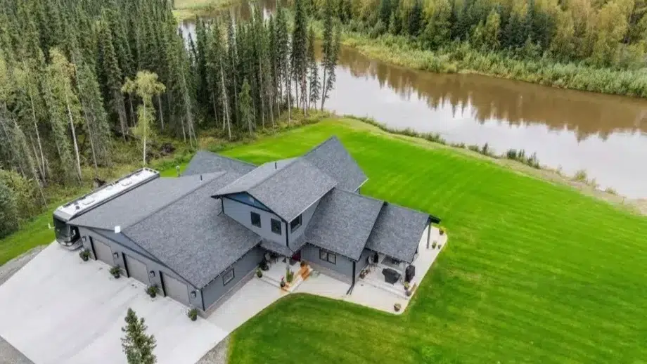 A spacious family home with a large yard, situated just beside a flowing river in Alaska
