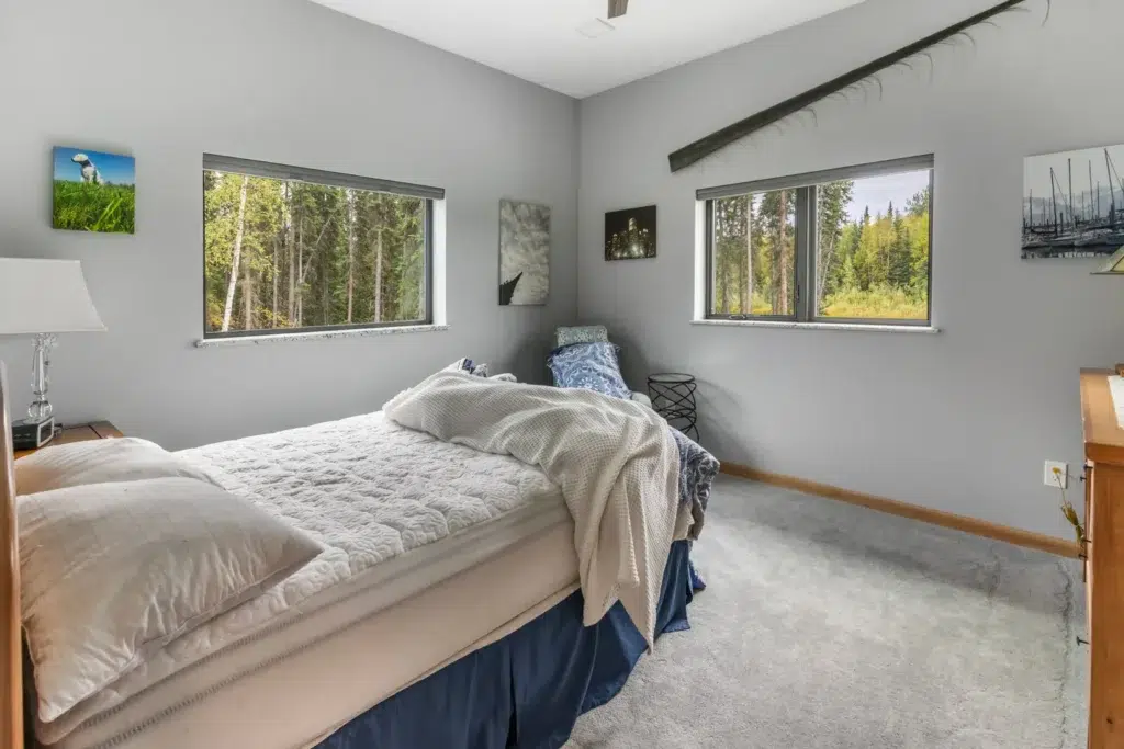 This corner bedroom showcases the stunning views from every direction of this home in Alaska